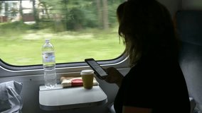 Kiev, Ukraine - July 24, 2018: A girl looks at a smartphone while traveling in a train car. Girl with a smartphone in the train car. The compartment of the international train.
