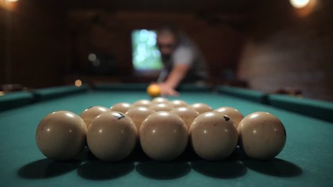 Man Playing Russian Billiards. First Blow Hit Breaking the Ball Pyramid. 4K Slowmotion.