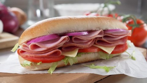 A delicious submarine hoagie sandwich with deli meat, lettuce, tomato, onion and cheese.