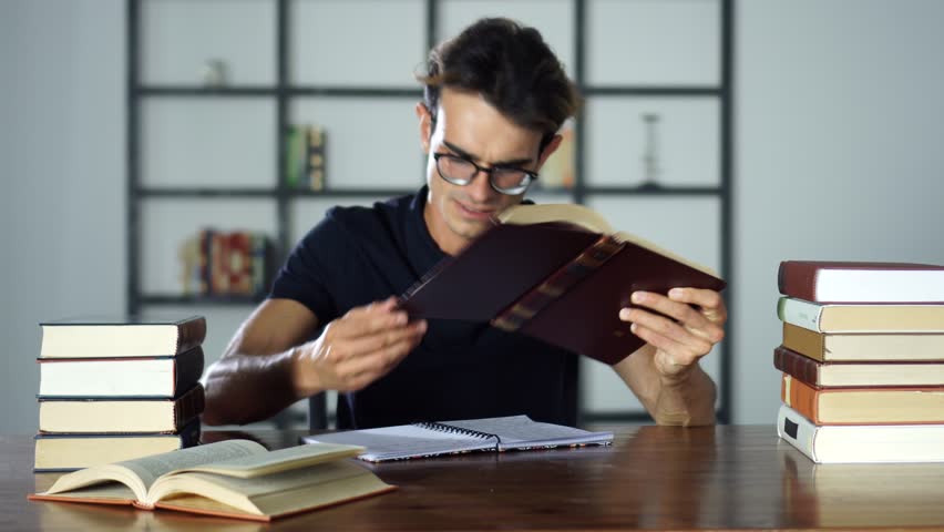 Stressed angry student screaming with open mouth while studying, reading books, cannot find any information from the textbook. Royalty-Free Stock Footage #1014621800