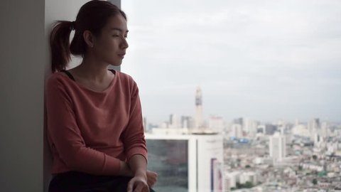 PTSD Mental health concept, Young depressed asian woman sitting alone near window in morning.