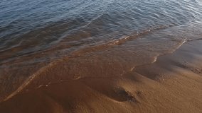 Video footprints in the sand near the sea, women's legs pass along the beach