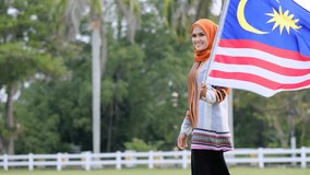 Malaysian Woman holding Malaysia Flag in Independence Day. - Powered by Shutterstock - Get 15% off with code: PIKWIZARD15