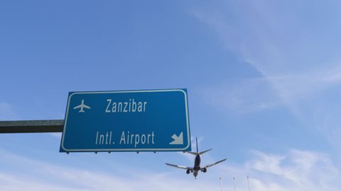 zanzibar airport sign airplane passing overhead
