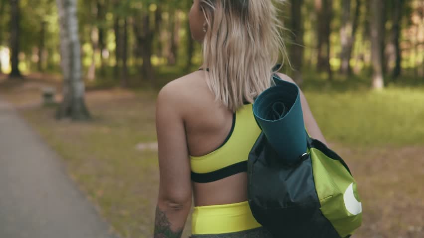 Fitness girls walk with sport bag. Young girls preparing to exercise or running, walking outdoor. Healthy lifestyle concept in slow motion