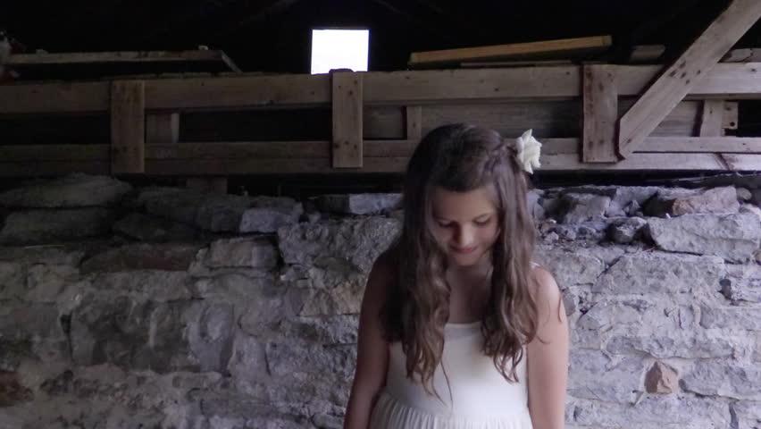 Pretty young girl in barn on the farm in Canada. Children on a country farm in Canada at sunset. Young children playing in rural country setting on the farm together during summer vacation.