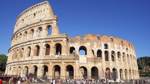 ROME, ITALY - CIRCA May 2018: Famous Italian attraction Colosseum in Rome. Veiw on ancient Flavius amphitheater Coliseum in capital of Italy. Tourists walking around. Camera moving from left to right