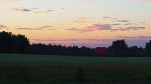 Heart shape aerostat in the fields in the evening