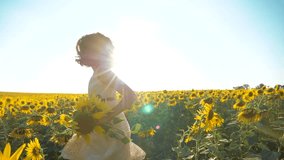 Happy little girl running happy free across lifestyle the field with sunflowers. slow motion video . smelling big sunflower on summer field. Delight of a pleasant smell. Summer holiday. concept