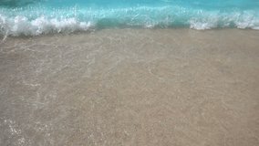 Slow motion video of wave in tropical turquoise clear water sandy beach