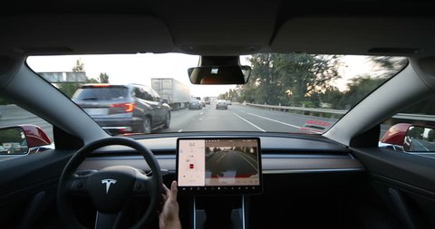 LOS ANGELES - AUG 2: Jose, 43, activates an automatic lane change by a Tesla Model 3 on Autopilot on August 2, 2018 in Los Angeles. Tesla plans to roll out more autonomous functions within the month.