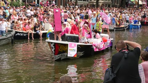 AMSTERDAM, THE NETHERLANDS – AUGUST 4, 2018: Barbie boat and visitors at the Canal Gay Parade 2018