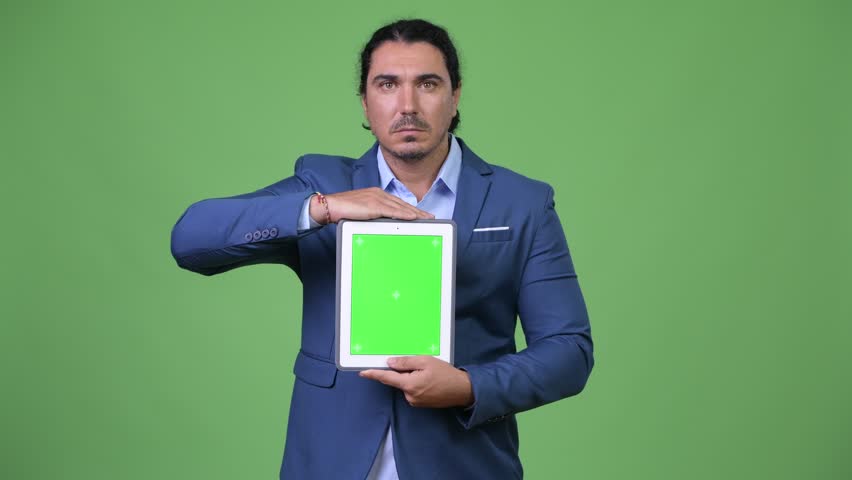 Handsome businessman thinking while showing digital tablet