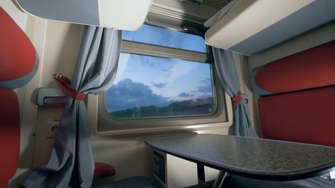 General view of a train's cabin in the twilight. Travelling by train concept. Railroad trip concept.