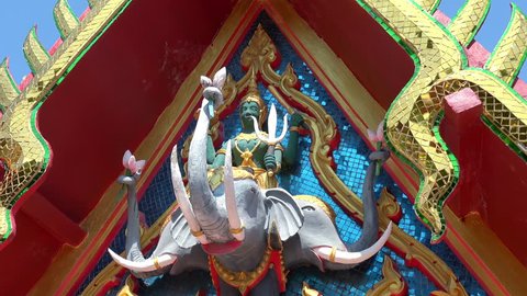 Sculpture of Hindu god Indra sitting on three-headed elephant Airaavatha decorating facade of Wat Phra Yai, Koh Samui island, Thailand. Decoration of temple exterior depicting Buddhist guardian deity.