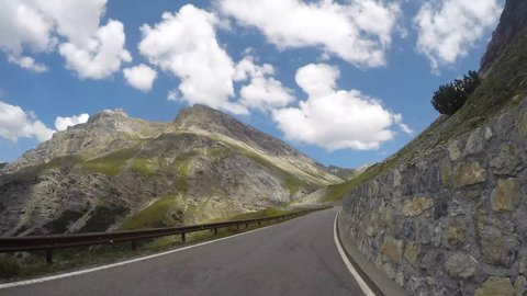 Bormio, Italy, July 28, 2018. Driving shot, vehicle point of view. Camera on car roof. Time lapse driving to the Stelvio mountain pass from the village of Bormio