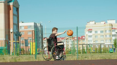 Disabled man plays basketball from his wheelchair, On open air 4k