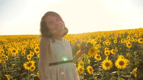 Dad and daughter walking along the field with sunflowers at sunset holding hands First-person view. Slow motion video lifestyle. follow me. little girl and boy teenager run by the hand over the field
