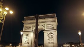 Night forward camera push-in to illuminated Arc de Triomphe at Place Charles De Gaulle in Paris, France
