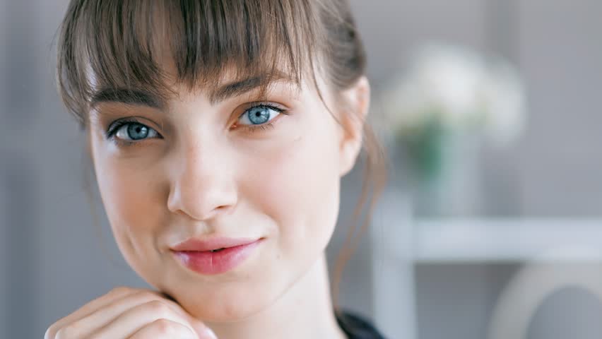 Close-up portrait face of young attractive European woman with dark hair and bangs | Shutterstock HD Video #1014703670