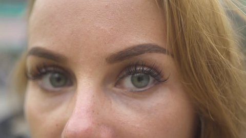 Close up woman face and eyes looking into camera. Face young woman with gray eyes and natural makeup