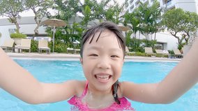 cute girl paly and selfie happily in the swimming pool