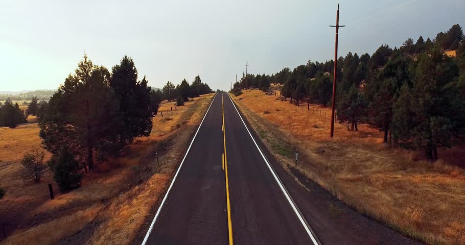 Drone flies over the national park road in the USA at sunset. Fire and dust in the sky, because of California fires. Atmospheric landscapes.