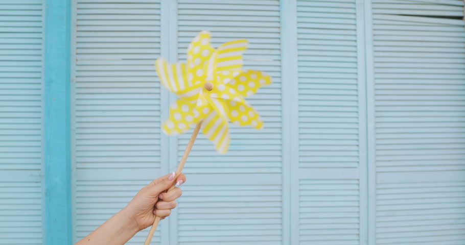 yellow pinwheel toy against blue blue deck. summer concept