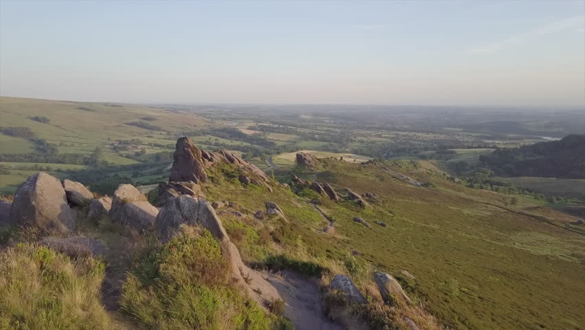 Aerial drone shot flying over spine of rocks at sunset.