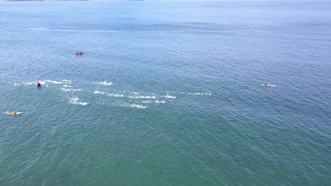 Drone pan circling ocean water swimming race around bouy