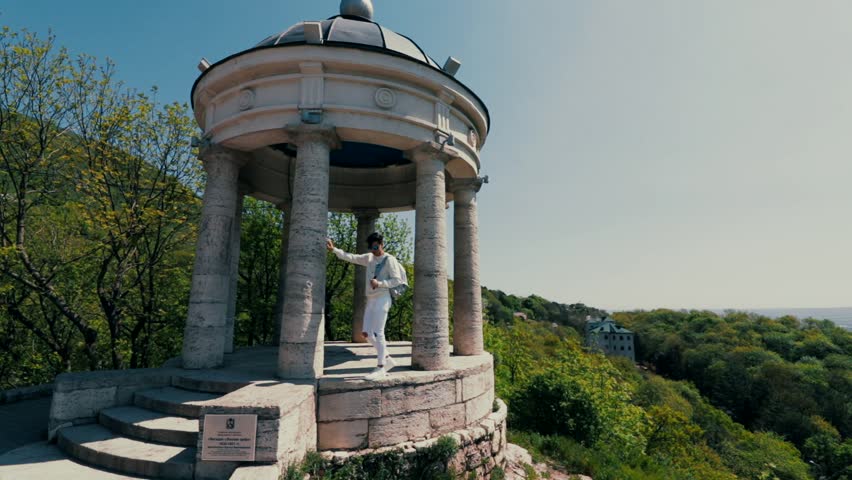 A young guy is standing near the aeolian harp in Pyatigorsk