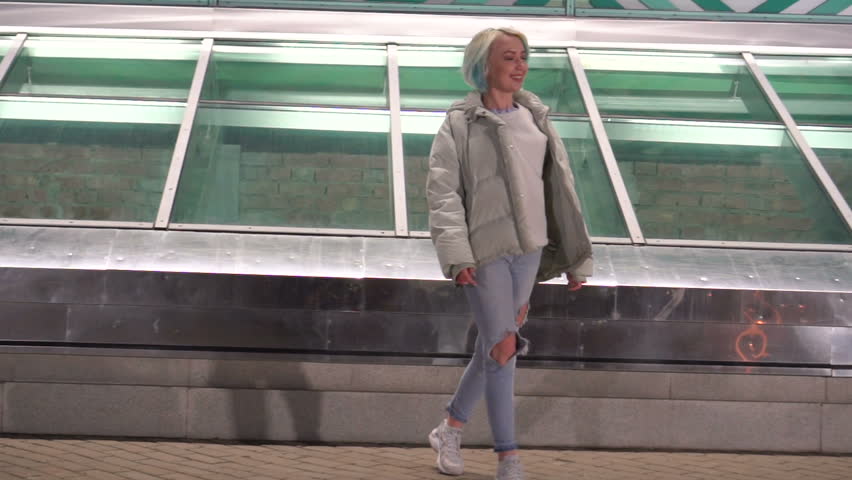 Young woman walking on the street at night.