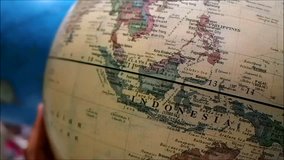 Close up video of a hand spinning a globe map