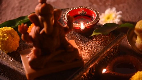 diwali diya with flower rangoli, sweets and gifts