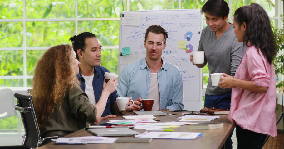 Group of five diversity young businessmen talking and drinking coffee together in modern office, concept for relaxation between hard work, lifestyle of workers. Royalty-Free Stock Footage #1014750743
