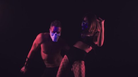 Man and woman dancing in skull masks