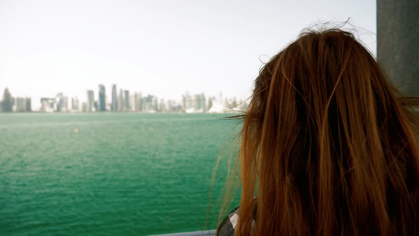Woman looking at beautiful view with skyscrapers in Doha Qatar.