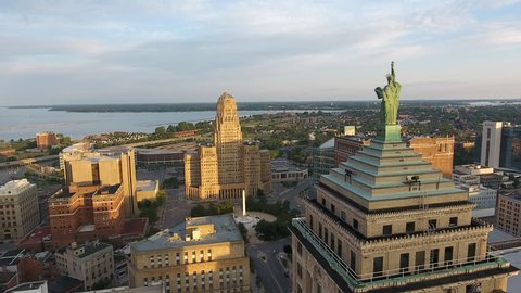 Statue of Liberty in Buffalo New York Immigration and Freedom. Aerial of Downtown Buffalo New York at Sunrise. Flying over the city of Buffalo NY in first light of the morning. Urban city scene.