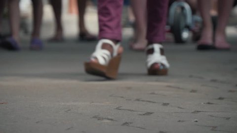 Close-up of foot walking people on the sidewalk. People hurrying about their business