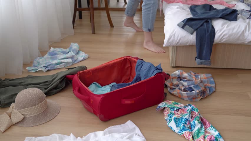 Someone important is coming to visit the Asian woman's house soon. She quickly threw everything into the suitcase to clean up this messy room. | Shutterstock HD Video #1014776426