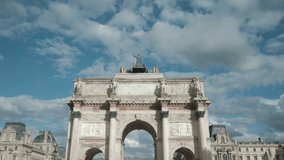 Forward dolly push in low angle view of centered Arc de Triomphe du Carrousel in Paris, France