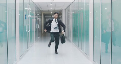 South asian businessman running down office hall. Office worker is late for work and hurrying with briefcase in hand. 4k