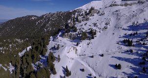 Aerial drone video still and side panning camera movement, panoramic view still and side panning of moving gondola ropeway ski lift at fir tree forest, early fresh snow