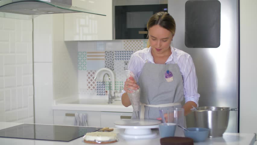 Attractive girl cooks in the kitchen. Quarantine, stay at home