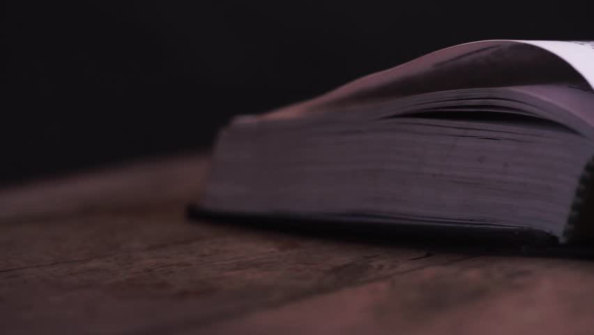 Open Holy Bible on a old wooden table, rotation 360 degrees. Dark background. Religion concept. Close up. Royalty-Free Stock Footage #1014797858