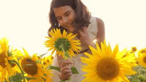 Happy portrait little girl on the field of sunflowers in summer. beautiful portrait little girl in sunflowers. slow motion video. girl teenager and sunflowers field lifestyle concept agriculture