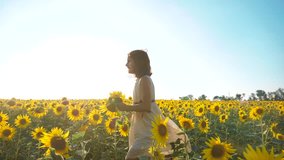 Happy little girl running happy free across the field with sunflowers. slow motion video. smelling big sunflower on summer field lifestyle. Delight of a pleasant smell. Summer holiday. concept