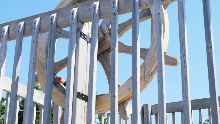 A cute little boy playing on a wooden pirate ship at the playground