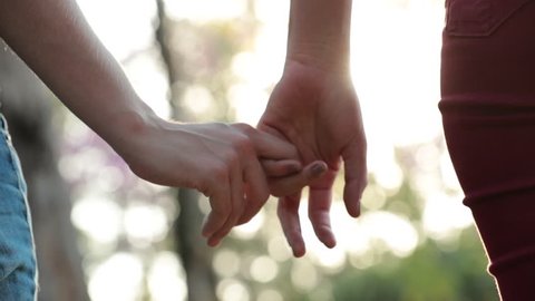 Close-up of disjoining hands, letting go of hands together