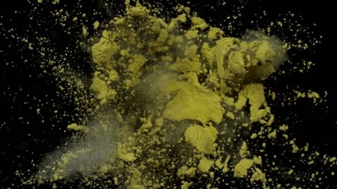 Color powder particles exploding into dust cloud